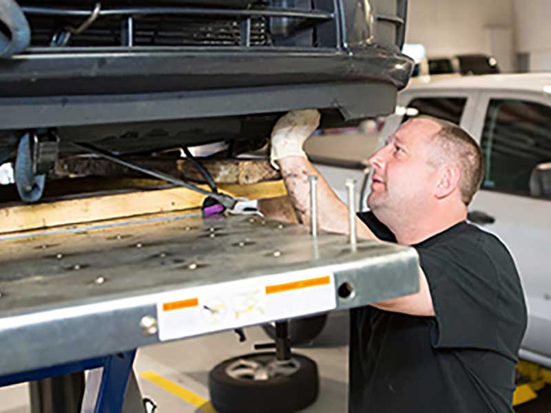 A service tech replacing the brakes of a vehicle